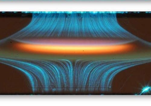 A laboratory flame established between the opposing fuel and air streams, showing the luminous soot zones and flow patterns.