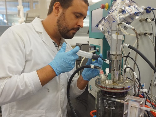 Moustapha Harb collects a water sample from the anaerobic membrane bioreactor.
