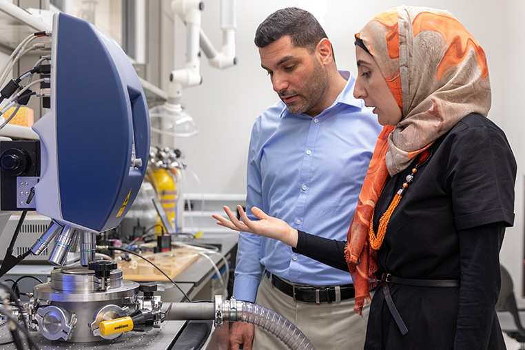 Mohammad Younis (back) and Nouha Alcheikh discuss the optimum thickness for the beam in their pressure sensor.